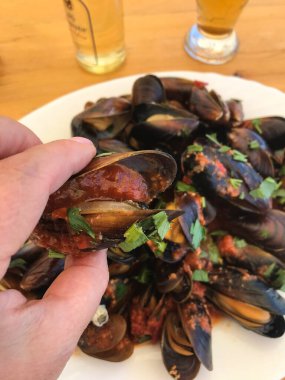 Restoranda bir tabakta şarap ve otla pişirilmiş midye. Balchik. Bulgaristan.