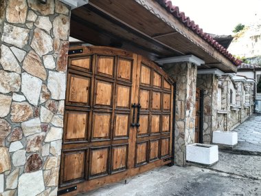 Eski ahşap kapılı eski bir binanın taş duvarı..