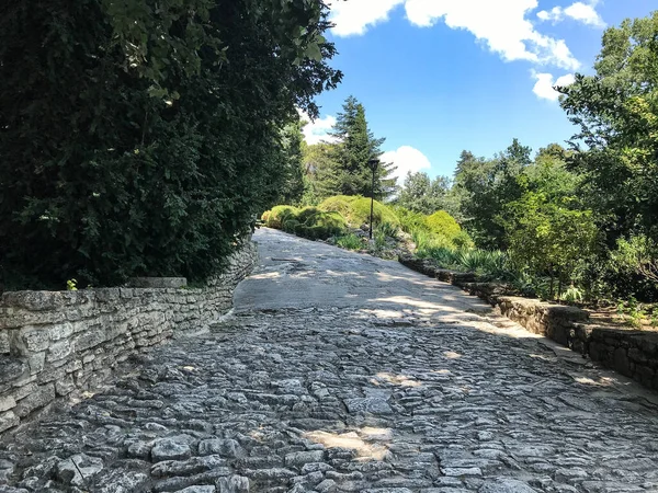 stock image The path in the park is paved with stone. Decorative trail or road in the garden of cobblestones. Walkway stones pattern texture. Landscape design, European landscape design.