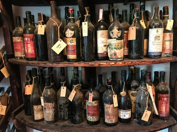Botol anggur berdebu vintage tua di lemari anggur Stok Foto
