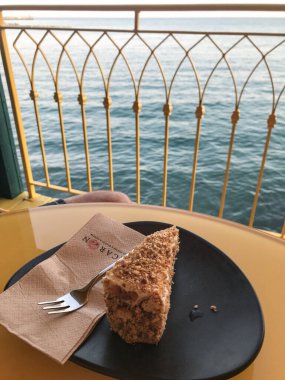 Kıyı kafesindeki bir masada siyah bir tabakta cevizli kek. Balchik. Bulgaristan.