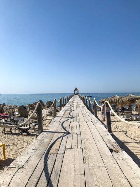 Mavi gökyüzüne karşı denize giden ahşap yol. Protaras. Kıbrıs. Nisan 2021.