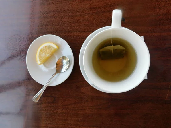 Grüner Tee in einer weißen Tasse auf einem Holztisch. — Stockfoto