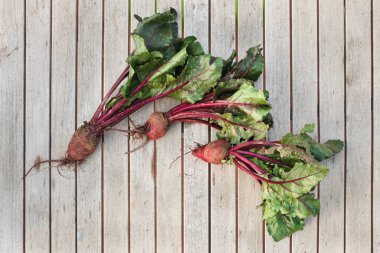 Tahta bir masada taze toplanmış pancar kökleri.