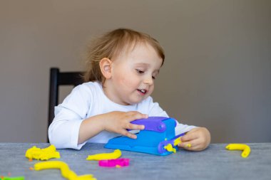 Masadaki renkli plastikten çıkan sevimli küçük çocuk kalıpları. Evde eğitim. Corona virüsü süresince çocuklarla yaratıcı zaman geçirme. Evde karantina..