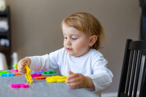 Glad Liten Unge Som Sitter Vid Bordet Och Leker Med — Stockfoto