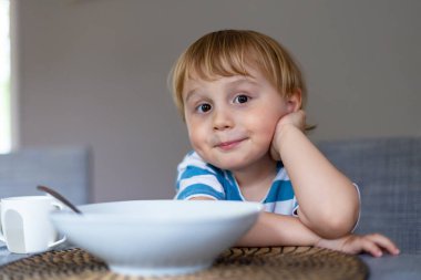 Evde İtalyan makarnası yiyen genç bir çocuk. Küçük çocuk içeride spagetti yemekten zevk alıyor. Tatlı çocuk ve sağlıklı yemek.