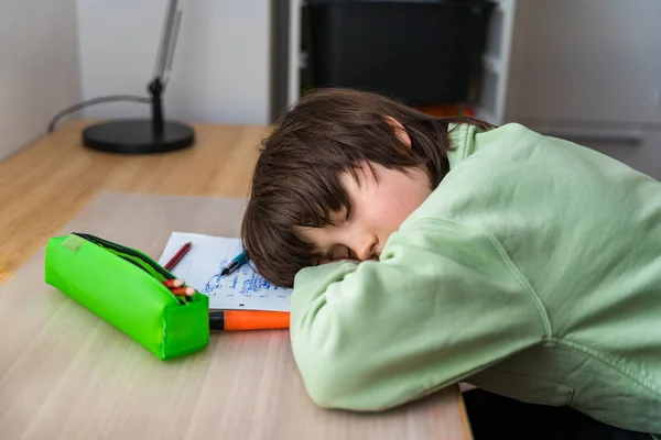 １０歳の少年は宿題をして家のテーブルに座っている 疲れて子供眠っているときに学校の抜粋顔上の机 — ストック写真