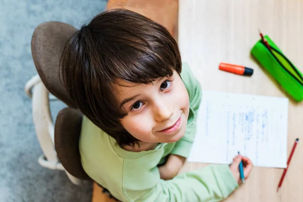 少年は宿題をして家のテーブルに座っている 集中した子供の執筆練習は喜びと ホームスクーロンの概念 — ストック写真