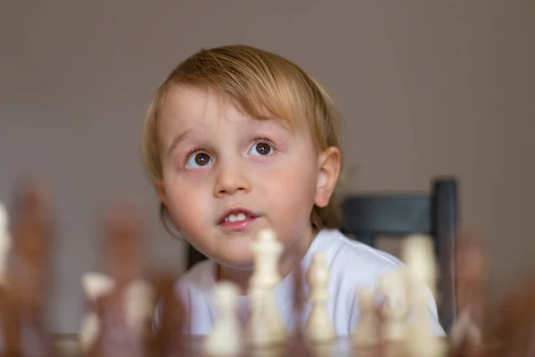 Menino Ruivo Nos óculos Sentado Em Casa E Jogando Xadrez Sozinho. Imagem de  Stock - Imagem de movimento, jogar: 208485515