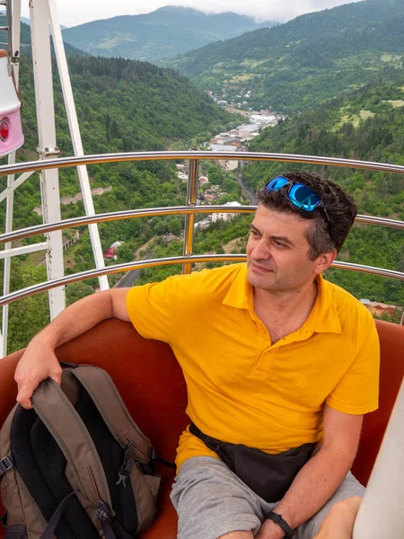 Çekici yetişkin adam dağlarda dönme dolapta dinleniyor.