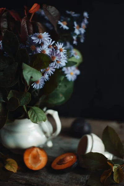Buquê de flores do jardim em vaso de barro perto de ameixa — Fotografia de Stock