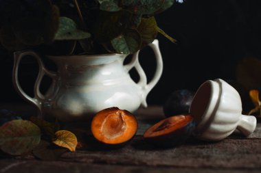 Sonbahar kır sahnesi, ahşap masadaki hasattan sonra eriği kes.