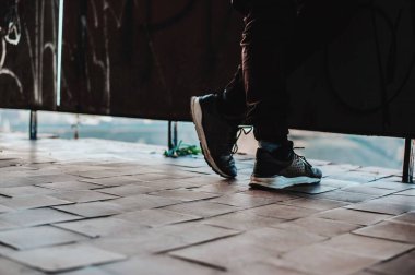 Çölün çatısında spor ayakkabıların içinde insan bacakları