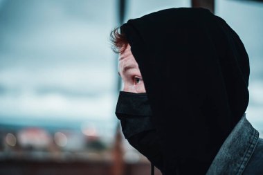 Siyah maskeli kızıl saçlı adamı dikkatle izleyin.
