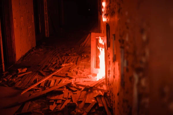 Burning wall in abandoned corridor with a lot of wooden shapes — Stock Photo, Image