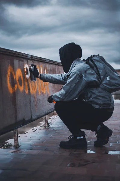 Siyah kapüşonlu anonim. Çatıda korona boyası var..