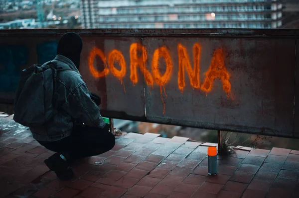 Protester on the roof writes corona with spray paint — Stock Photo, Image