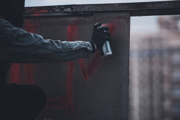 Рука в перчатках протестующего делает знак в старой стене