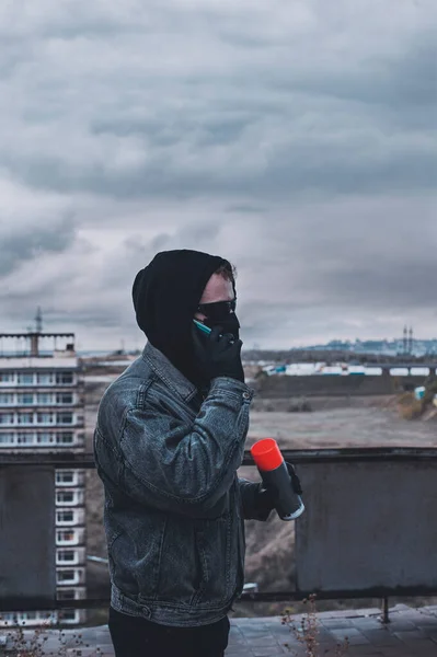 Young graffitist speak phone while preparing can of spray paint — Stock Photo, Image