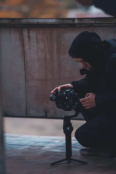 Young operator in hood shoots on camera with Stab on the roof of abandoned house — Stock Photo, Image