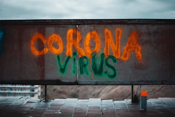 Corona vírus cantar escrever com um fluorescente brilhante pode pintar laranja e verde — Fotografia de Stock