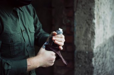 Yeşil gömlekli protestocu, harekete geçmeden önce molotof kokteyli fitilini kontrol etti