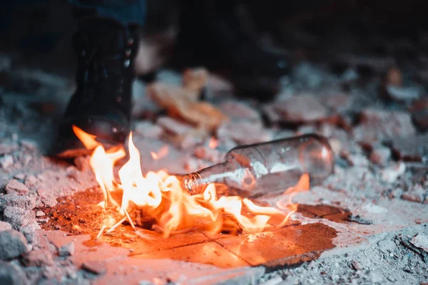 Kokteyl molotofu, protestocuların ağır botlarının yanında alev aldı.
