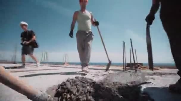 Dynamische beelden van nivellering cement met schop op bouwplaats — Stockvideo