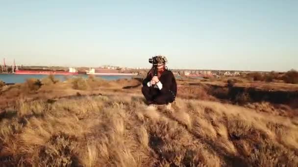 석양에 풍력 발전기를 촬영하는 카메라로 소녀를 쏘는 모습 — 비디오