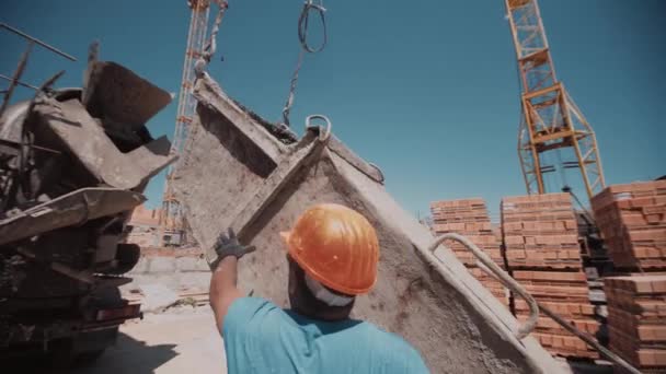 Pembangun menempatkan wadah di dekat pencampur beton untuk mengisinya — Stok Video