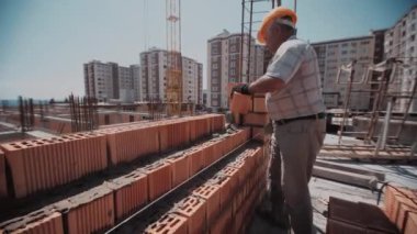 Duvarı tuğla döşeyen bir inşaatçıya kapatın.