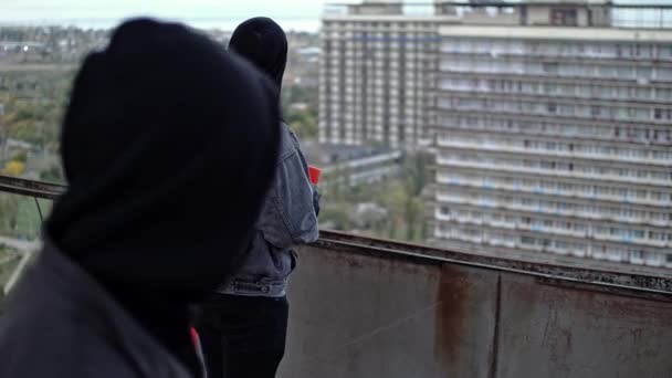 Jong tuig in de buurt verbergen zijn identiteit in de tijd van het maken van graffiti aan de muur — Stockvideo
