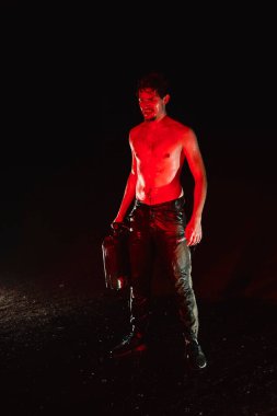 Kırmızı ışıktaki yakışıklı çıplak genç adam, gaz tüpüyle kal. 