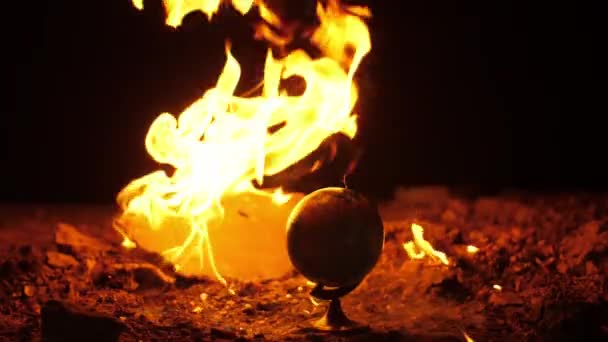 Gaz în flăcări în jurul globului pe o podea de ciment în întuneric — Videoclip de stoc