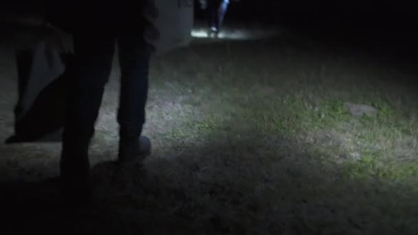 Group of people walks with Lanterns and bags on a nature in the dark — Stock video
