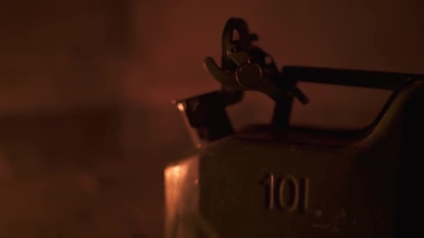 Close up shoot of flap on the gasoline canister in the dark illuminated by fire — Vídeo de stock