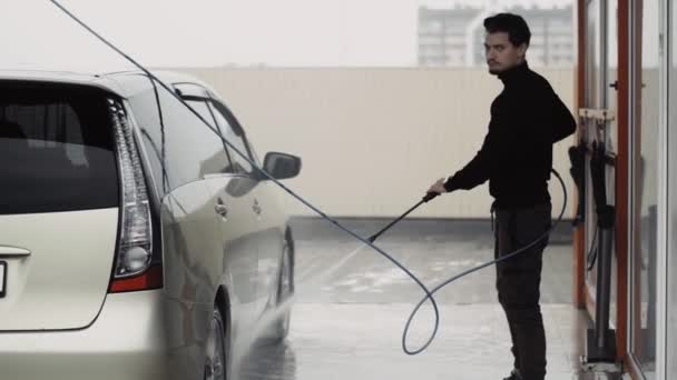 Çekici bir adam arabasını yıkarken iyi bir parmak izi gösterir. — Stok video