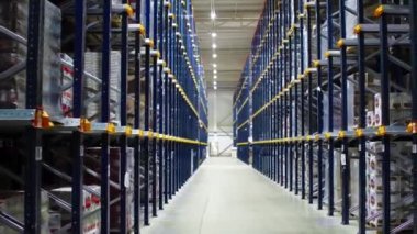 Büyük bir lojistik merkezinde malzeme depolamak için metal rafların arasında çekim yapmak..