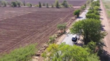 Güneşli bir günde ağaçlarla yeni kır yolunun üzerinde uç.