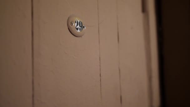 男人们手拿手表敲着有29个号码的旧门上. — 图库视频影像