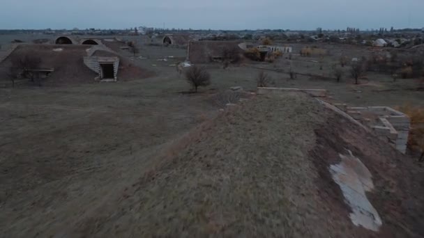 Dynamische luchtvlieg boven verlaten hangars op verloren militaire luchtmachtbasis — Stockvideo