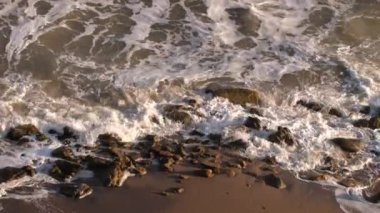 Kıyıdaki büyük taşlara vuran fırtına deniz dalgalarının yavaş çekim görüntüleri.