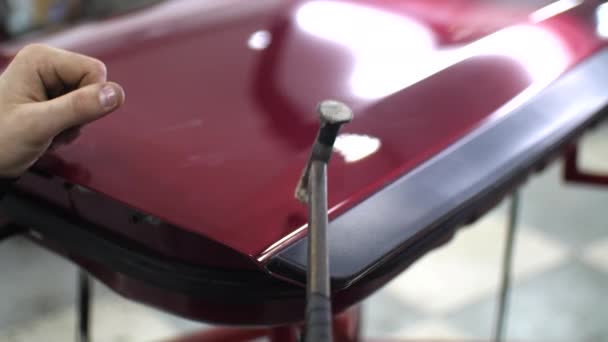 Martelo close-up, que bate no carro vermelho para alinhar amassados sem pintura — Vídeo de Stock