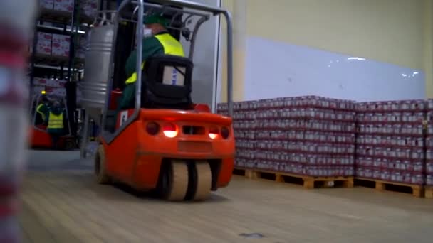 Red forklift on the fabric storage moves a big metal tank — Stockvideo