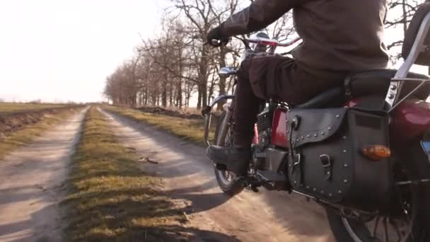 Швидка їзда по брудній дорозі, біля мотоцикліста на червоному подрібнювачі, через осінній ліс — стокове відео