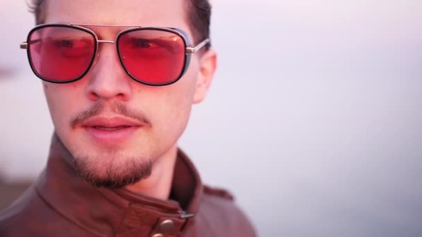 Close shot of nervous young male walk at the sea coast in sunset sun — Stock Video