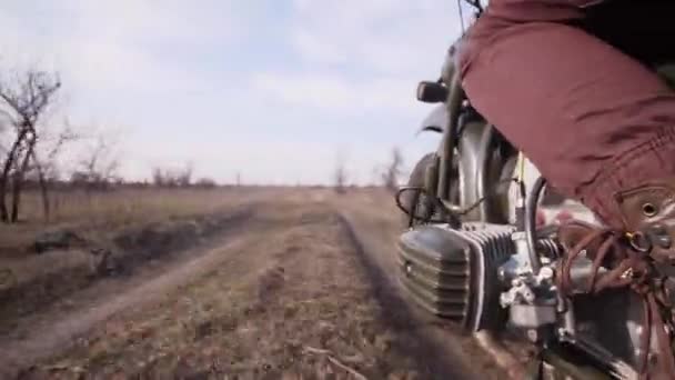 Мотоцикл швидко рухається по брудній сільській дорозі через поле в осінній день — стокове відео