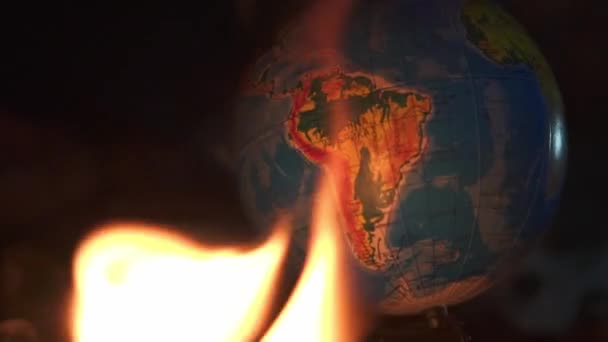 El fuego toma un globo terrestre sobre formas de cemento de edificios abandonados — Vídeo de stock