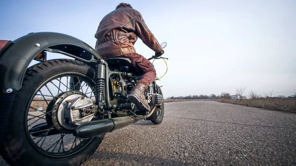 Близкая съемка винтажных мотоциклов колесо на верхом старой пустой дороге — стоковое фото